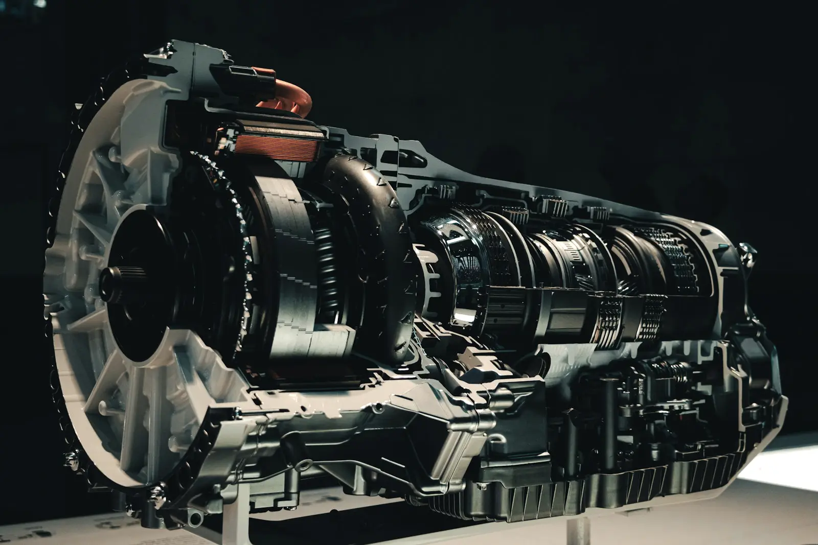 Cutaway of an automatic transmission on a display stand, showing the torque converter, stacked clutch packs and valve body.