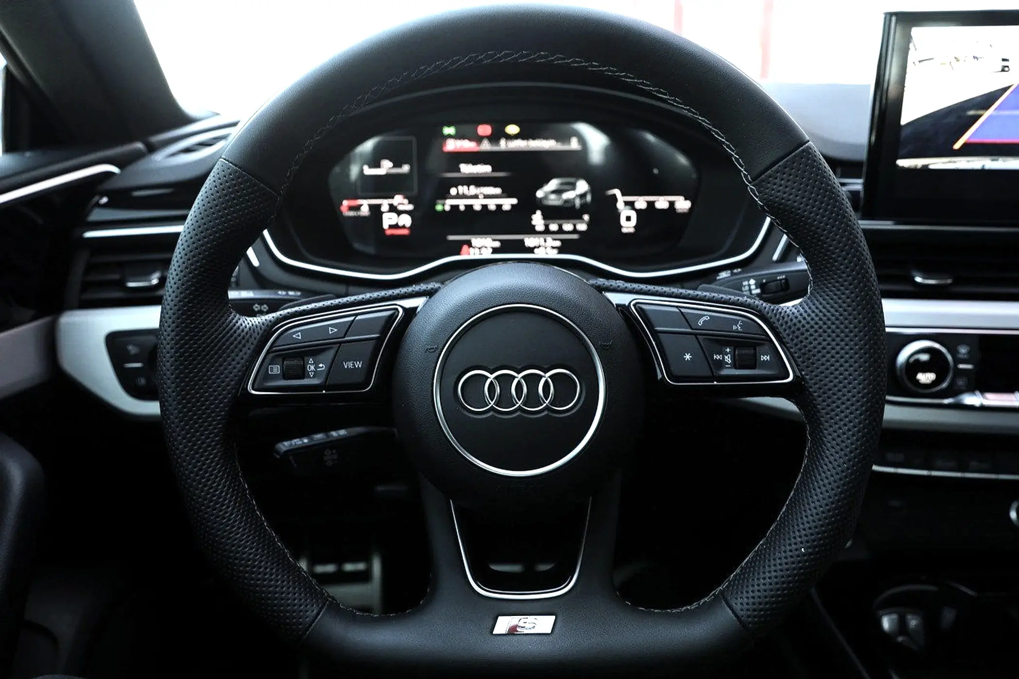 Audi car steering wheel with digital dashboard display.